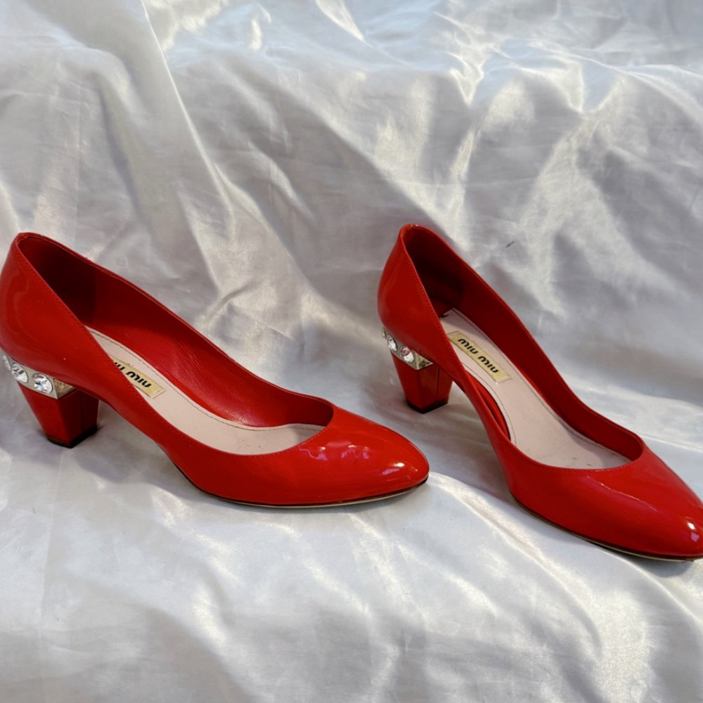 Miu Miu red patent leather heel pumps with crystal embellishments on the heels